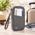 Grey family travel document organiser beside passports and luggage
